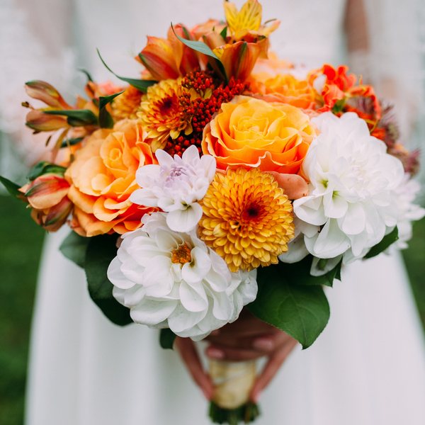 белые и оранжевые цветы в букете невесты