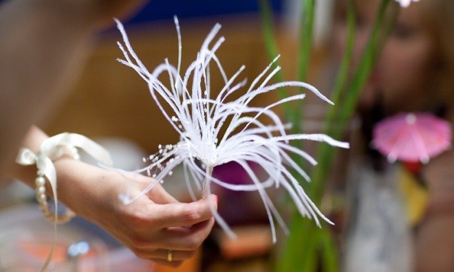 Чтобы сделать серединку, на проволочках равной длины завязываем несколько бисеринок, собираем в пучок перышки и проволоку с бисером, одной из проволочек фиксируем «ножку»