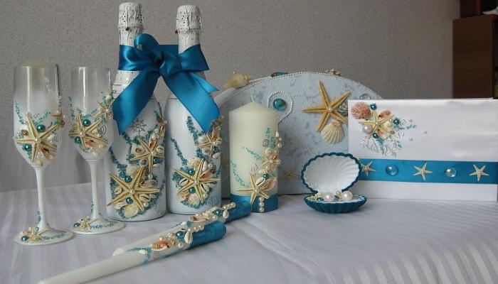 Элегантно украшенные по-морскому свечи, бутылки шампанского и другие свадебные аксессуары