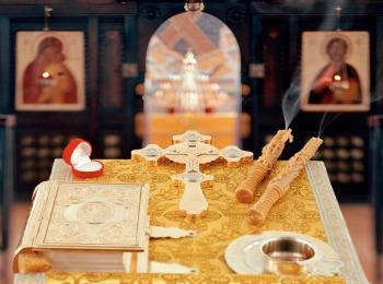 Евангелие, крест, венцы и свечи на аналое