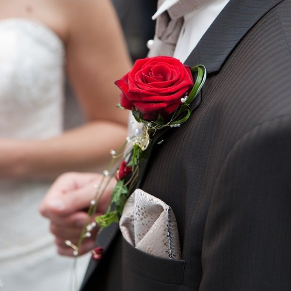 красный цветок в пиджаке жениха