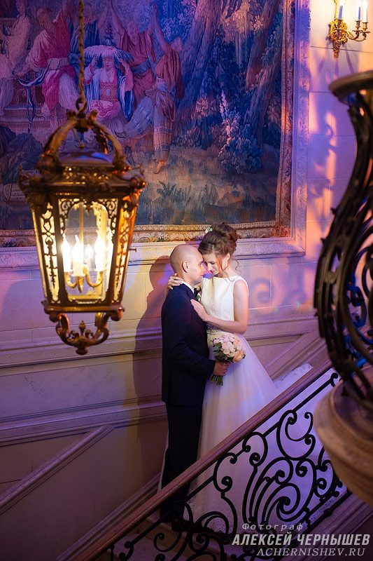 молодожены на фоне кованной лестницы и фонаря