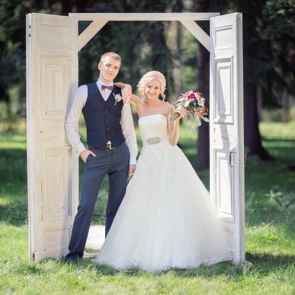 молодые в нарядах позируют на свадьбе