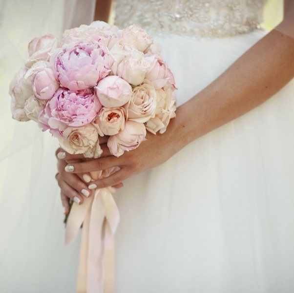 Невеста видит себя в зеркале в свадебном платье