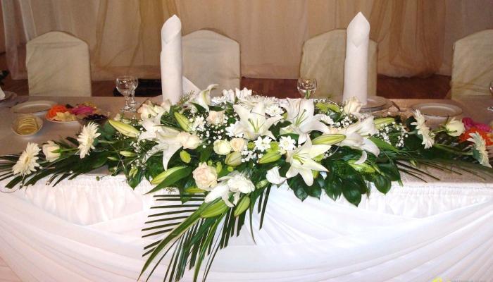 Передний край стола для молодоженов обычно украшают длинной композицией из цветов