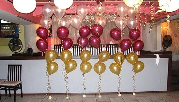 Прозрачные, красные и желтые воздушные шарики у бара на свадебном банкете