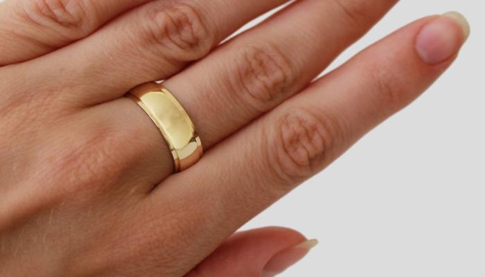 Широкое кольцо из золота выпуклой формы на руке