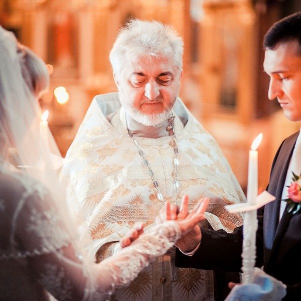 священник венчает пару