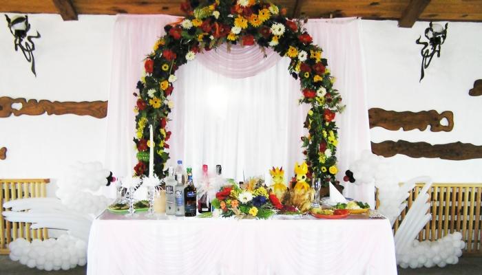 За столом молодоженов можно сделать арку из цветов - это станет отличным местом для фотографирования