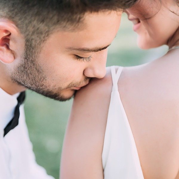 жених скромно целует невесту на свадьбе