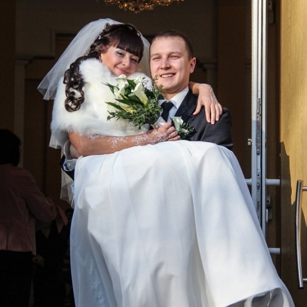 жених выносит невесту из ЗАГСа