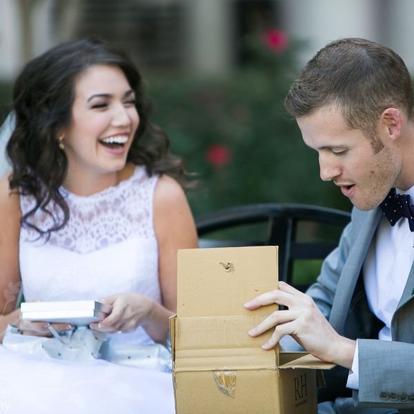 жених заглядывает в коробку с подарком
